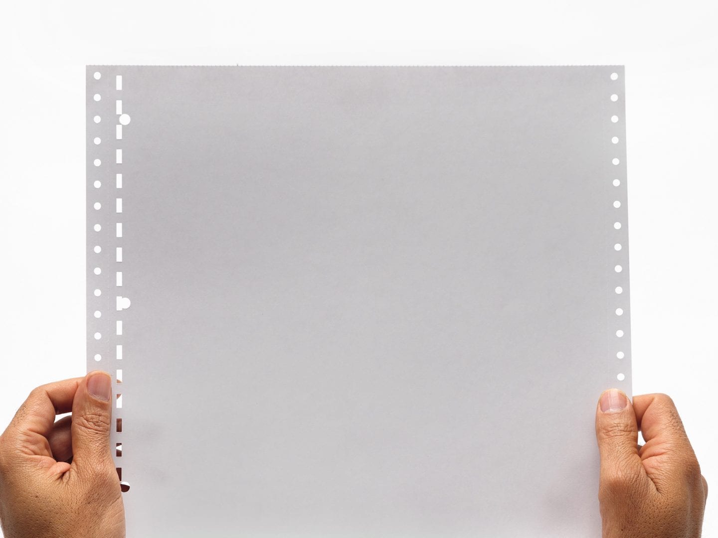 White Fanfold Tractor Feed Braille Transcribing Paper Being Held Close Up