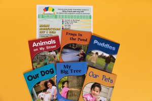 A collection of six colorful books titled Animals on My Street, Frogs in the Pond, Puddles, Our Dog, My Big Tree,  and  Our Pets on a yellow background.
