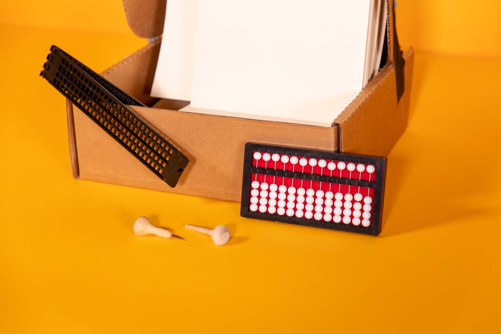 Student-Starter-Kit-close-up_1-00350-00_web student starter pack box containing abacus, transcribing paper, and cell slate with saddle stylus