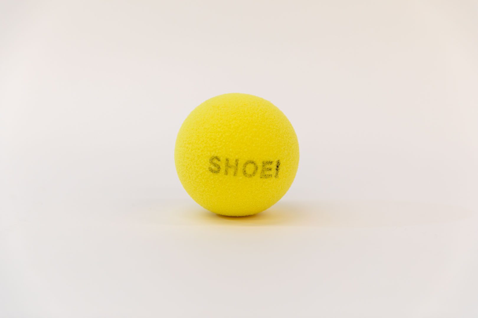 Sound-Adapted-Tennis-Ball_web A yellow tennis ball with the word "SHOEI" printed in black