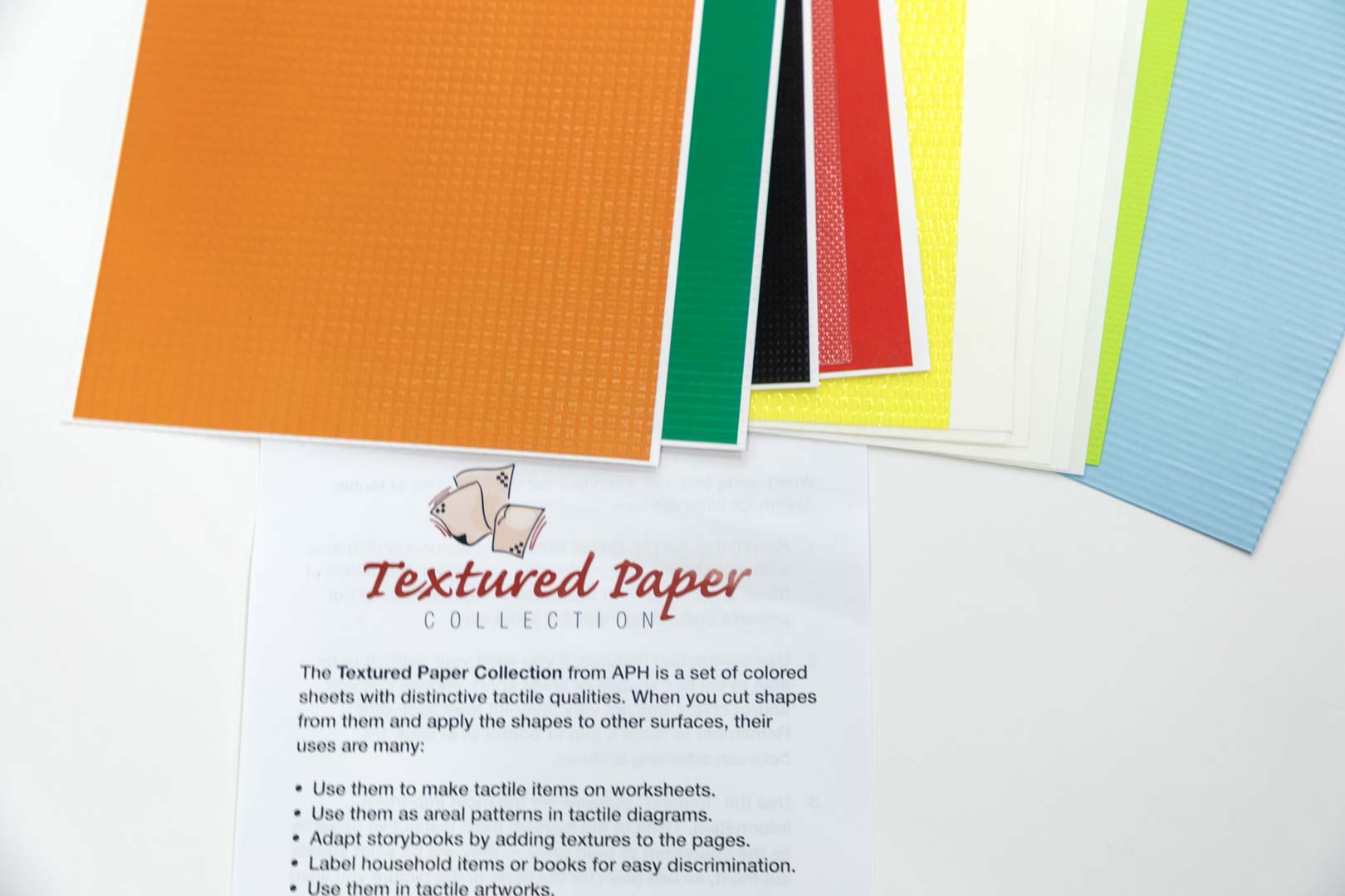 Textured-Paper-Collection_close-up_1-03275-00 A stack of multi-colored textured paper fanned out with the textured paper insert positioned underneath.