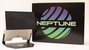 An opened Neptune device next to the black branded Neptune box. The device is white with a black base and a black monitor. The box has a purple and green graphic that reads, 